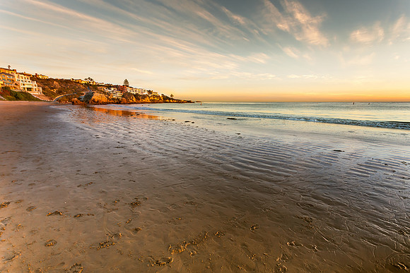 Houses on the cliff overlooking the ocean at sunset